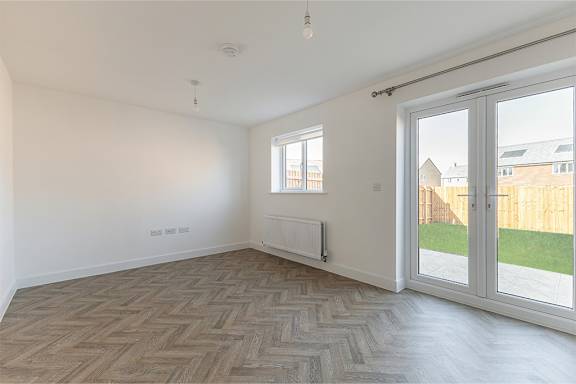 A room with a herringbone patterned floor and a sliding glass door.
