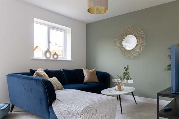 A living room with a blue couch and a white coffee table.