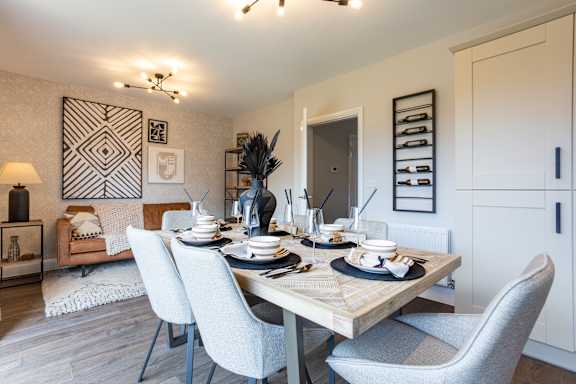 A dining room with a table set for a meal.