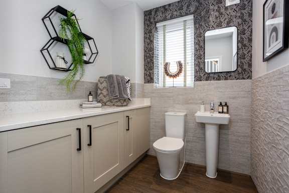 A bathroom with a toilet, sink, and mirror.