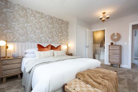 A bedroom with a large bed and a wooden dresser.