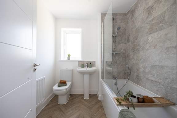 A bathroom with a toilet, sink, and bathtub.