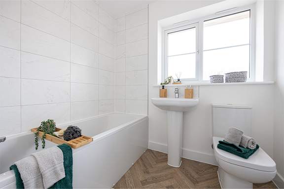 A white bathroom with a tub, toilet, and sink.