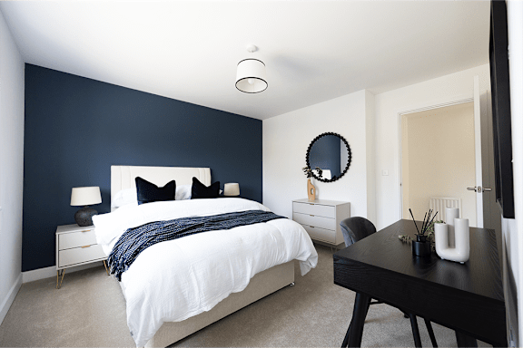 a bedroom with a white bed and a blue wall