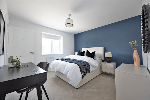 A bedroom with a bed, nightstand, and chair.