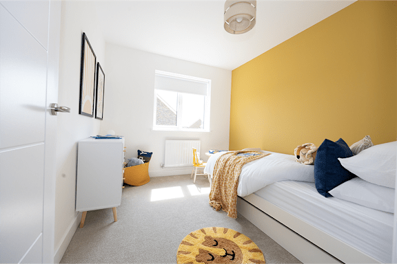 a bedroom with a bed and a yellow wall
