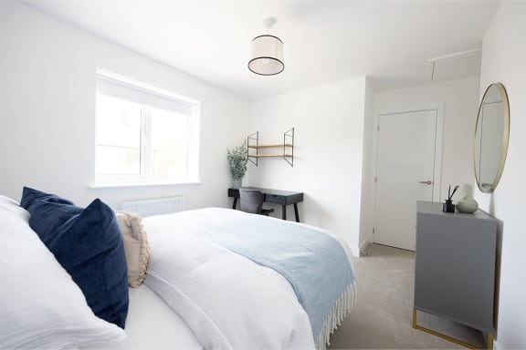 a bedroom with a bed and a dresser and a window