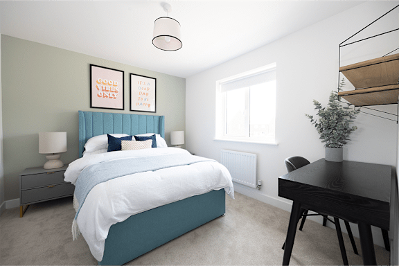 A bedroom with a bed, desk, and chair.