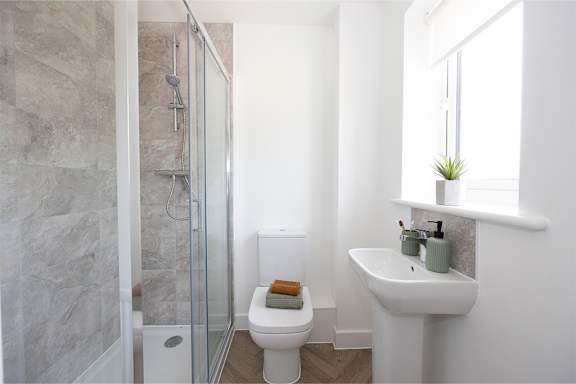 a white bathroom with a shower toilet and sink