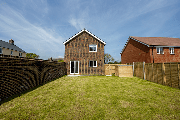 a back garden with a house and a fence