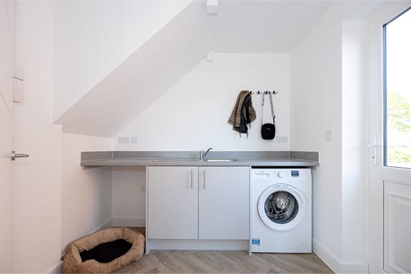 a white washer and dryer in a white laundry room with a washing machine