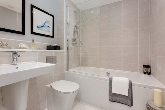 A white bathroom with a toilet, sink, and bathtub.