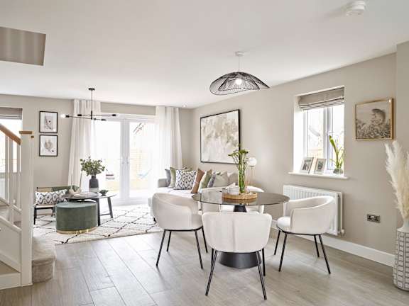 A modern dining room with a round table and white chairs.
