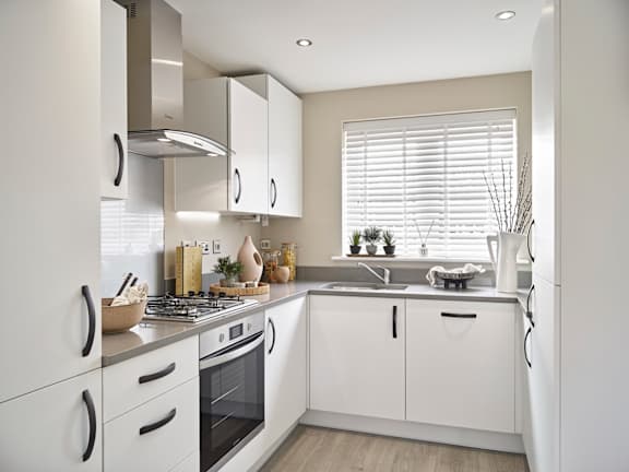 A modern kitchen with white cabinets and appliances.