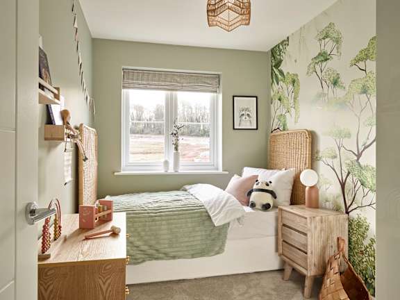 A bedroom with a bed, a nightstand, and a window.