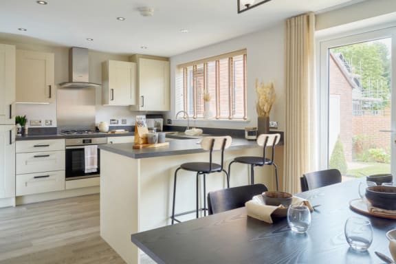 a kitchen and dining area with a table and stools