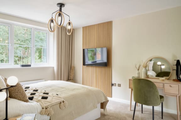 a bedroom with a bed and a desk with a chair and a television