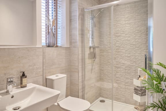 a white bathroom with a shower and a sink