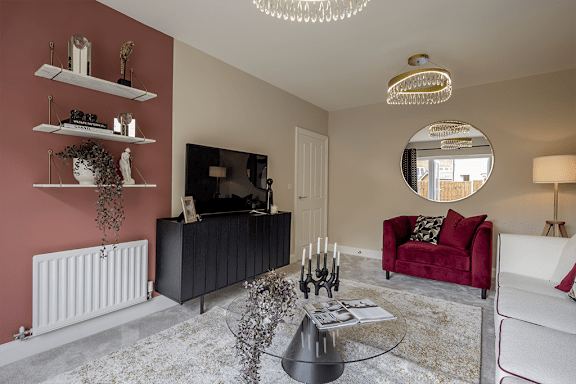 A living room with a red sofa and a chandelier.