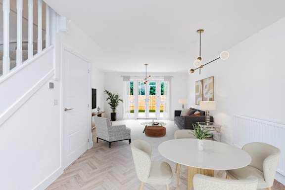 A white dining room with a round table and chairs.