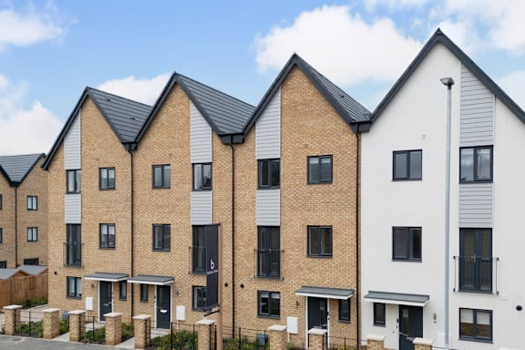 A row of modern townhouses with brick and white exteriors.