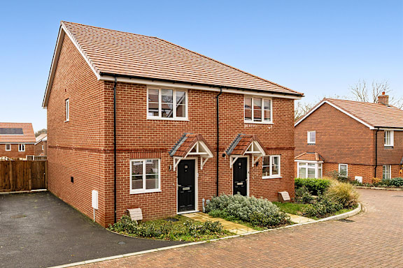 A red brick house with a black door and windows.