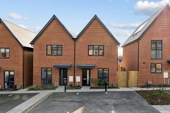A row of red brick houses with black doors and windows.