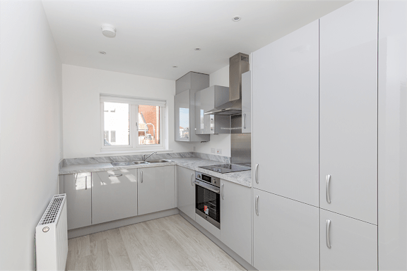 A modern kitchen with white cabinets and stainless steel appliances.