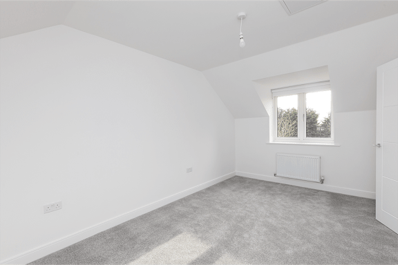 A room with a window and a radiator on the floor.