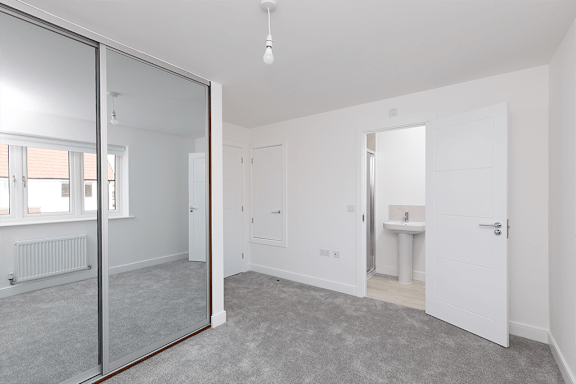 A room with a carpeted floor and a glass door.
