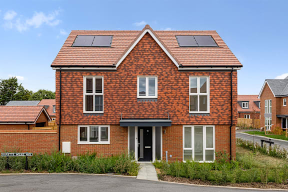 A red brick house with a black door and windows.