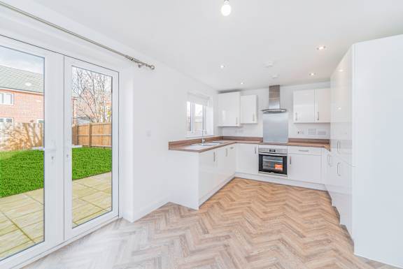 A modern kitchen with a herringbone patterned floor.