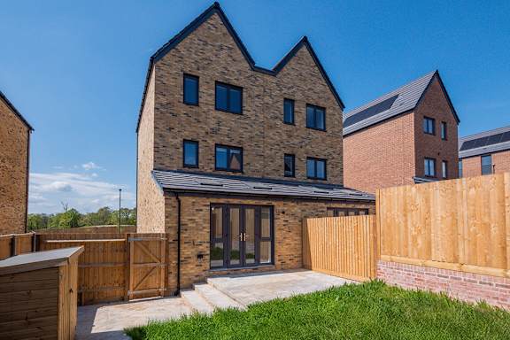 A modern house with a brick facade and a wooden fence.