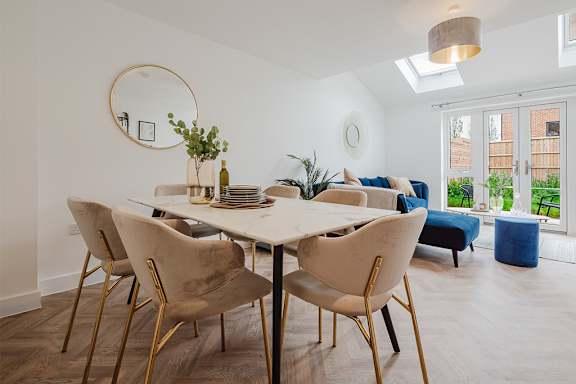 A dining room with a white table and chairs.