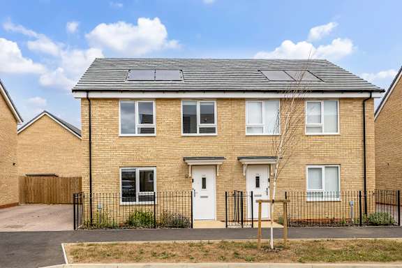 A three-bedroom house with solar panels on the roof.