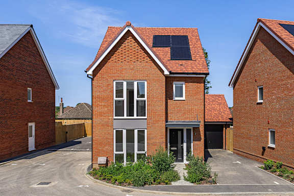 A red brick house with a black door and windows.