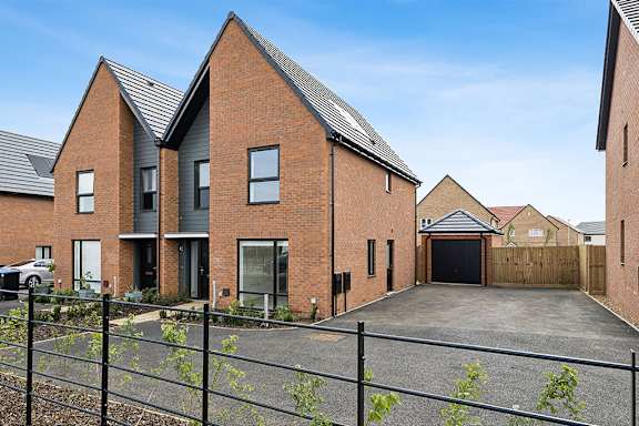 A modern brick house with a black gate in front.