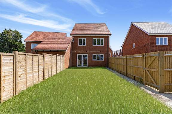 A house with a red roof and a wooden fence.