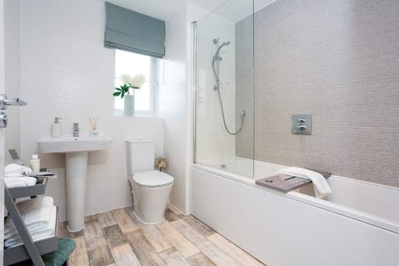 A white toilet sits next to a white sink in a bathroom.