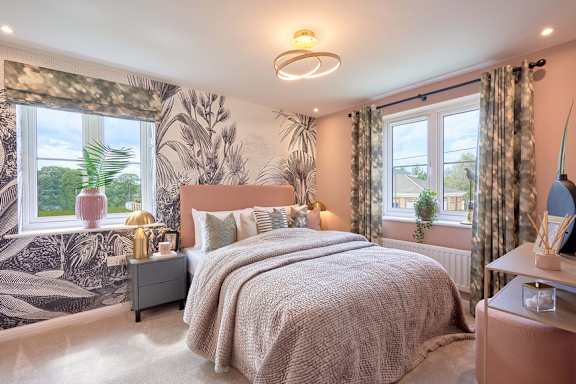 A bedroom with a large bed and a wallpapered wall.