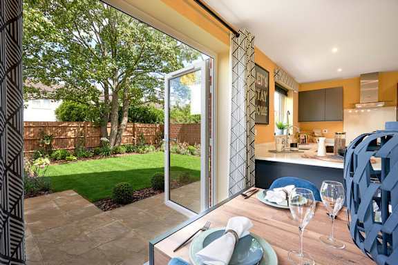 A dining table set with a view of a backyard.