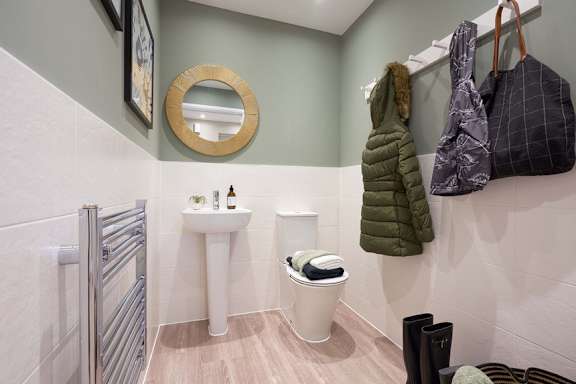 A bathroom with a white sink and a round mirror.