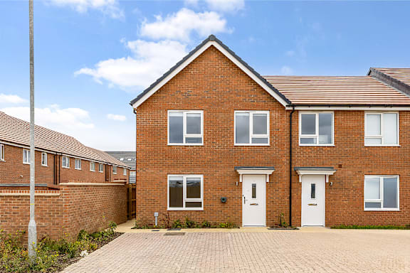 A red brick house with a white door and windows.