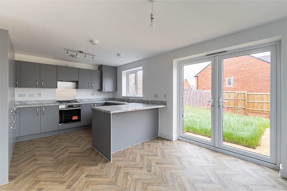 A kitchen with a marble countertop and a wooden floor.