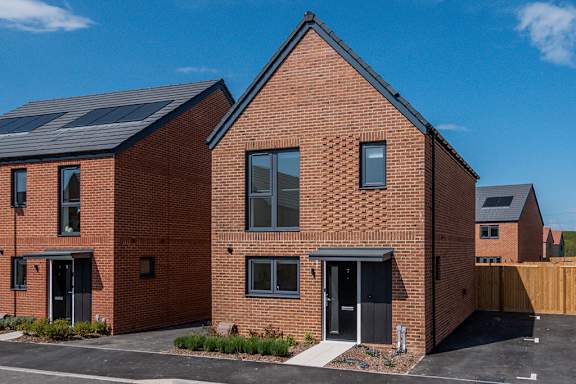 A red brick house with a black roof and a black door.