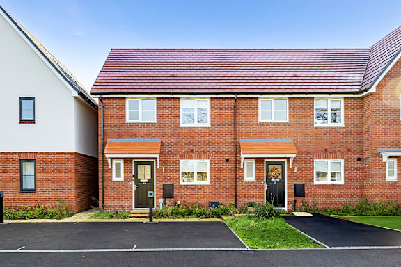 A red brick house with a black door and windows.