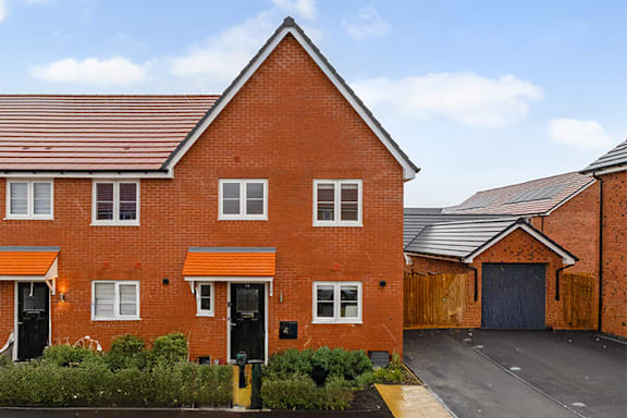 A red brick house with a black door and windows.