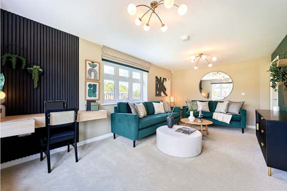 A living room with a green couch and a black chair.