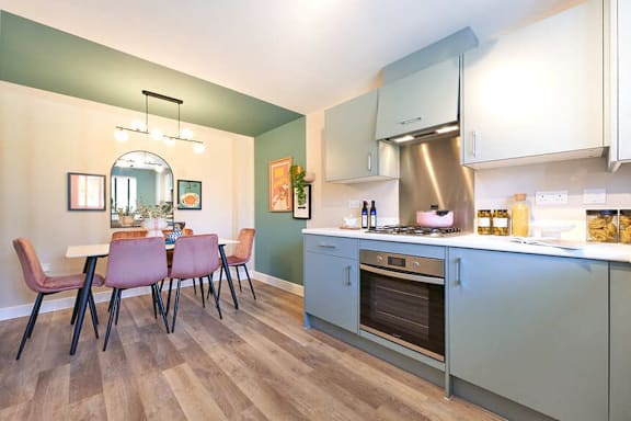 A kitchen with a table and chairs.