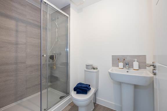 A bathroom with a toilet, sink, and shower.